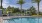 a pool with lounge chairs and palm trees around it