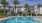 a pool in front of a building with a covered gazebo