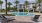 a pool with chairs and a building in the background
