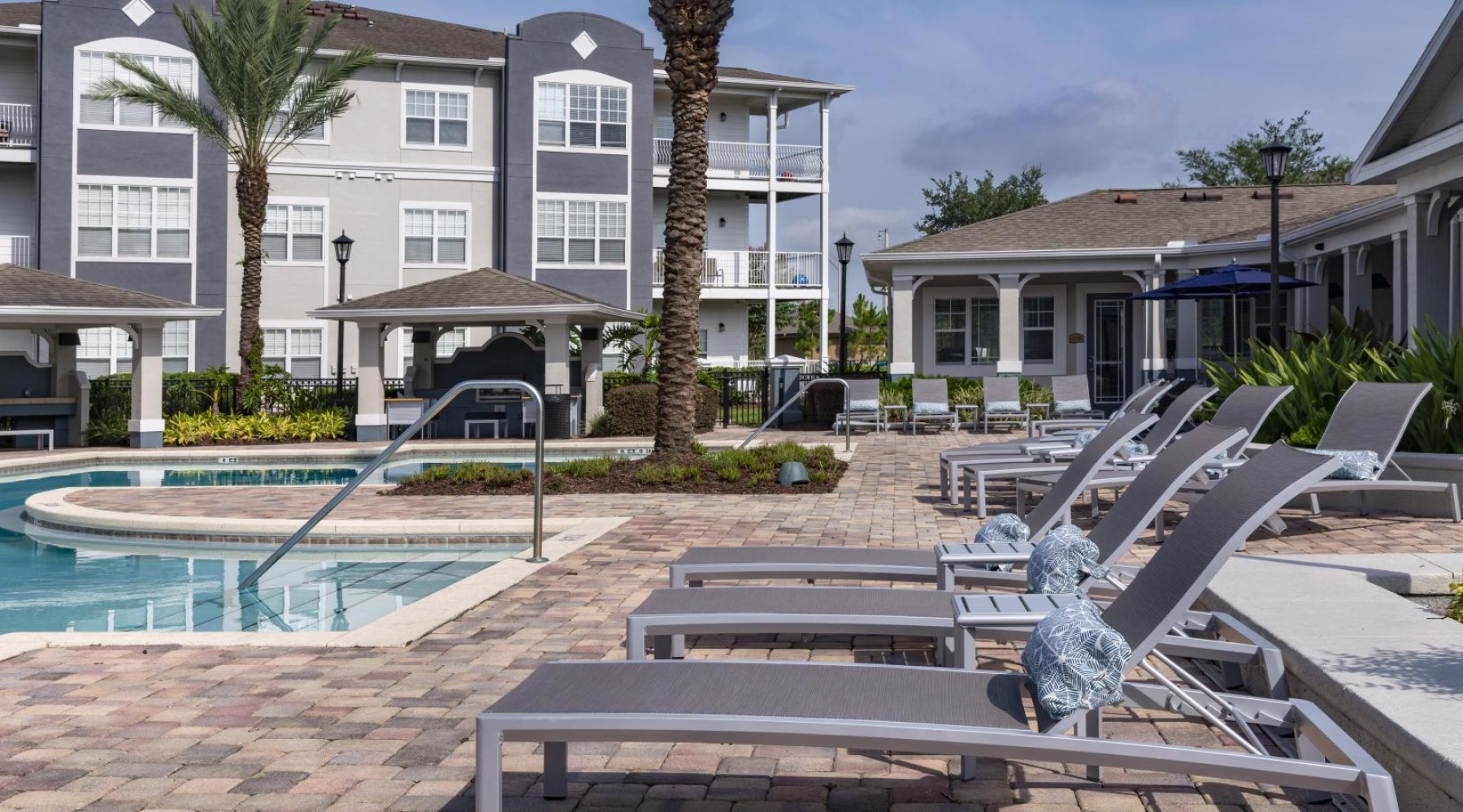 a pool with lounge chairs and a building in the background