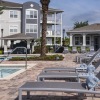 a pool with lounge chairs and a building in the background